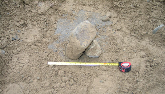 Figure 4 is a large photo of an out-of-spec rock found among the cover material