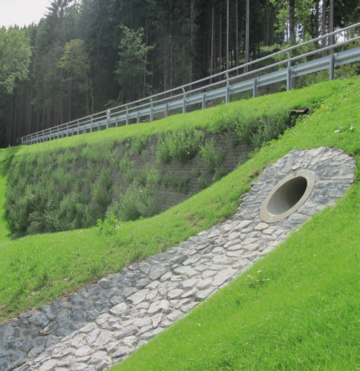 Photo of roadway embankment repair with vegetation growing from the reinforced system (as designed)