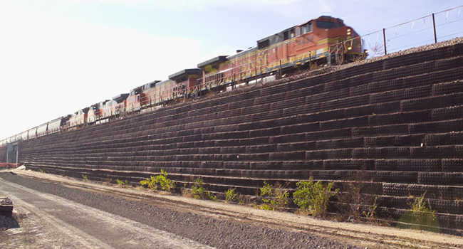 Image of MSE wall with railway running above. Reinforcement is a major topic of Geo-U 2020