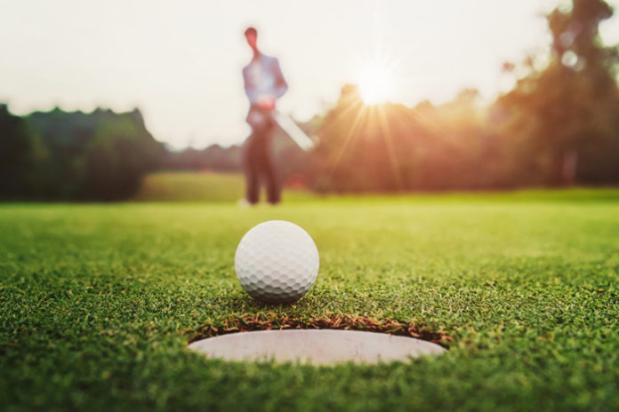 golf player putting golf ball into hole, image by lovelyday12 via shutterstock license